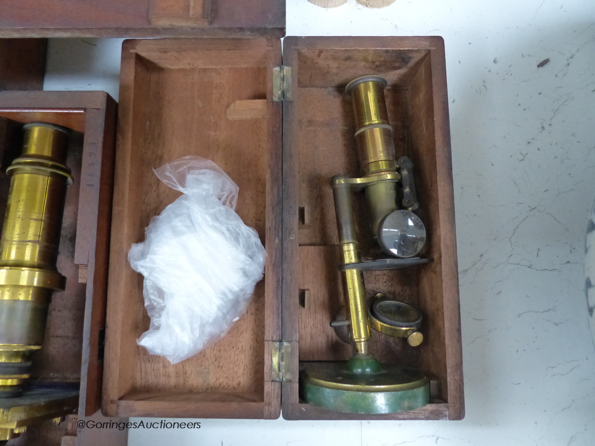 Three mahogany cased travelling microscopes and cased lenses